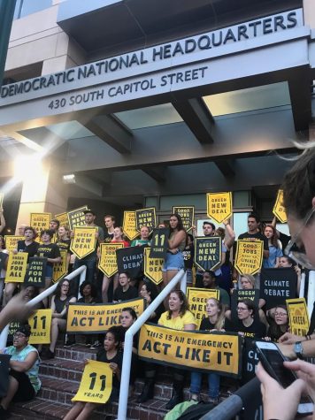 Protesters from the Sunrise Movement sing on the steps of the Democratic National Headquarters at 430 S. Capital St. They are protesting the DNC’s refusal to host a climate debate. (Sasha Fernandez/AWOL Magazine).