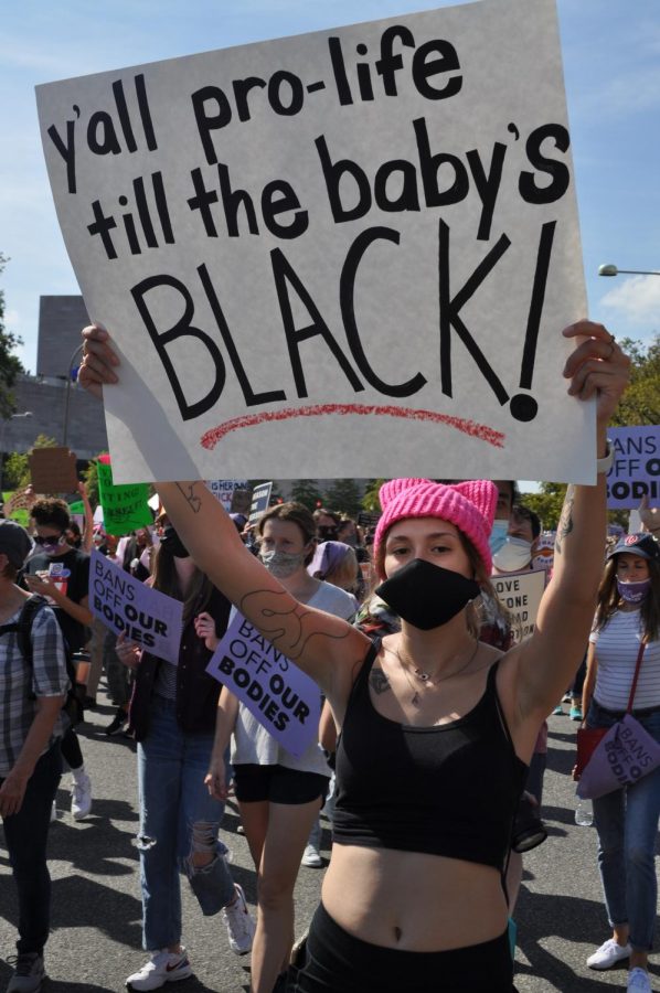 A protester holds a sign reading, “Y’all pro-life til the baby’s black!”